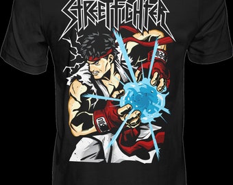 May include: Black t-shirt featuring a graphic of a character from the Street Fighter video game series. The character is Ryu, in a fighting pose, with his fist clenched and a blue energy ball in his hand. The text "STREET FIGHTER" is printed in white above the character.
