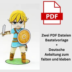Puede incluir: Una figura de papel de un personaje con cabello rubio, una túnica azul y un escudo, sosteniendo una espada. La figura está sobre una base verde. El texto en la imagen dice "PDF" y texto en alemán.