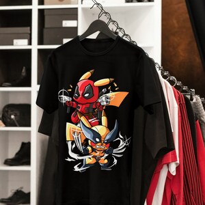 Puede incluir: Camiseta negra con un estampado gr&aacute;fico de Deadpool y Wolverine vestidos de Pikachu. Los personajes sostienen armas de fuego y est&aacute;n rodeados de balas.