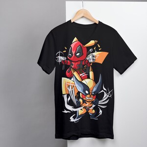 Puede incluir: Camiseta negra de cuello en V con un estampado gr&aacute;fico de Deadpool y Wolverine como Pikachu. Deadpool sostiene dos pistolas y Wolverine sostiene sus garras.