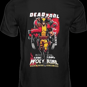 Puede incluir: Camiseta negra con un gr&aacute;fico de c&oacute;mic de Wolverine cargando a Deadpool. El dise&ntilde;o incluye las palabras "DEADPOOL" y "WOLVERINE" en blanco y amarillo, con texto adicional en rojo y amarillo. La camiseta es de "THE COMIC LEAGUE".