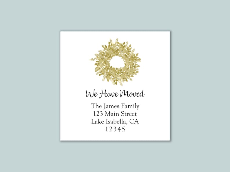 May include: A square white card featuring a gold watercolor wreath illustration at the top. The text reads: We Have Moved, The James Family, 123 Main Street, Lake Isabella, CA 12345. The design uses a combination of script and serif fonts.