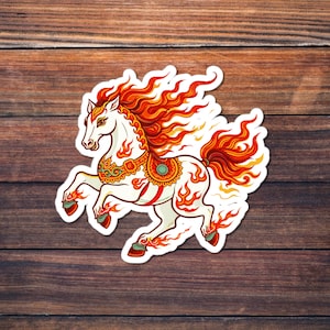 Peut inclure: Un autocollant blanc représentant un cheval stylisé avec une crinière et une queue rouge et orange flamboyantes. Le cheval a des accents décoratifs dorés et turquoise et des flammes autour de son corps, sur fond de bois.