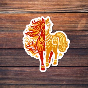 May include: A sticker featuring a stylized horse design. The horse is split vertically, with one side in fiery red and orange flames and the other in gold and yellow with floral accents. The sticker is on a wooden background.