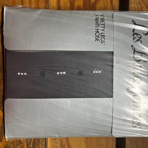 May include: Package of black pantyhose with the brand name "Les Belles Femmes" and the text "Pretty Legs, Panty Hose".