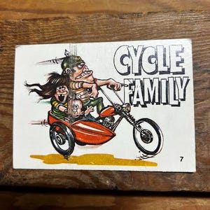 Puede incluir: Una portada de cómic vintage con una familia de dibujos animados en una motocicleta con sidecar. El título "CYCLE FAMILY" está en letras negras en negrita. La ilustración muestra a un hombre, una mujer y un niño montados en una moto roja. El número 7 está en la esquina inferior derecha.