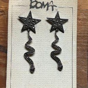 May include: A pair of sterling silver earrings with a star design and a dangling, twisted, chain-like detail. The earrings are on a white card with the word "BOMA" printed on it.