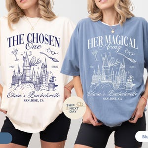 Może przedstawiać: Kremowe i dżinsowe niebieskie koszulki z grafiką zamku, sowy i napisami "The Chosen One" i "Her Magical Army". Koszulki są dla wieczoru panieńskiego Olivii w San Jose, CA.