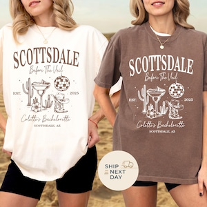 May include: Two t-shirts, one cream and one brown, with a desert-themed graphic. The design includes the text "SCOTTSDALE Before The Veil" with a cactus, cocktail, disco ball, cowboy boot, and the text "Colette's Bachelorette".