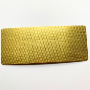 May include: A rectangular, gold-colored object with a woven texture. The object has rounded corners and a slightly reflective surface, suggesting a metallic material. The weave pattern is consistent across the entire surface.