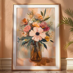 May include: A framed floral painting featuring a bouquet of pink, orange, and yellow flowers in a glass vase. The artwork has a soft, pastel color palette and is displayed on a wall with a gold frame.