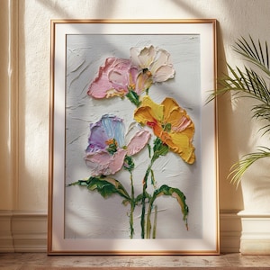 May include: A framed floral painting with a textured, impasto style. The artwork features colorful flowers in shades of pink, yellow, and blue against a white background. The painting is displayed in a gold frame, adding a touch of elegance to the floral art.