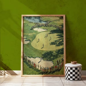 K&ouml;nnte beinhalten: Ein gerahmter Vintage-Golfplatzdruck. Das Kunstwerk zeigt einen gr&uuml;nen Golfplatz mit Golfern und Zuschauern. Der Druck befindet sich in einem Holzrahmen und lehnt an einer gr&uuml;nen Wand. Ein schwarz-wei&szlig; karierter Hocker steht vor dem Druck.