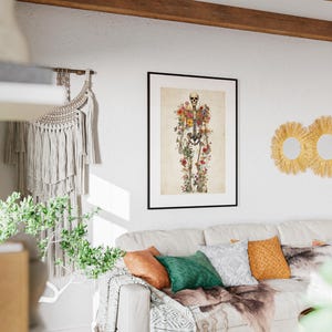 May include: A framed print featuring a skeletal figure adorned with colorful flowers. The artwork hangs above a white sofa with decorative pillows and a faux fur throw. Three round, woven wall mirrors are also visible.