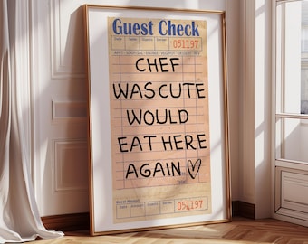 Könnte beinhalten: Gerahmter Druck eines Restaurant-Bon im Vintage-Stil mit dem Text "CHEF WAS CUTE WOULD EAT HERE AGAIN" in Schwarz. Der Rahmen ist goldfarben, an einer Wand mit Holzboden.