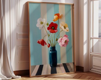 May include: A framed painting of a floral arrangement, featuring poppies in shades of red, pink, orange, and white, in a dark blue vase. The background has blue and white stripes. The frame is gold, and the painting leans against a white wall.