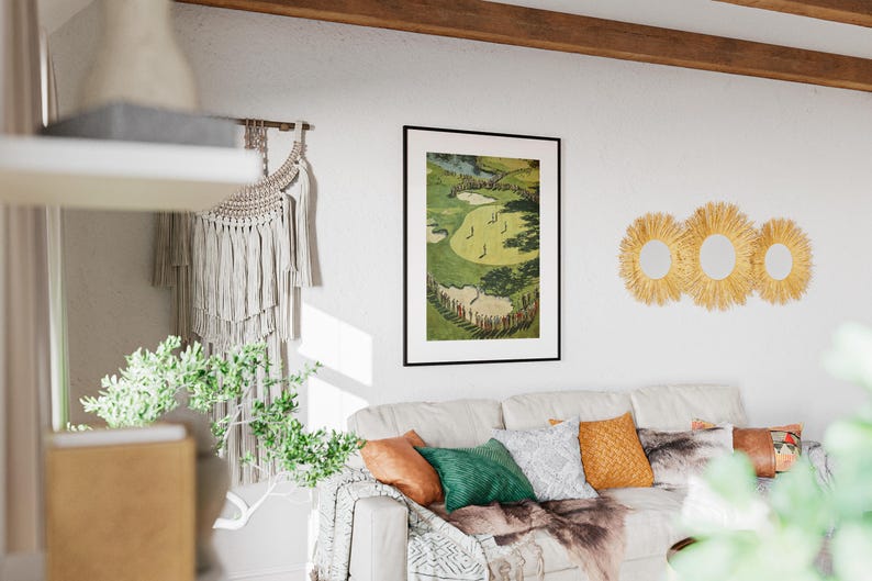 K&ouml;nnte beinhalten: Ein gerahmter Golfplatzdruck h&auml;ngt &uuml;ber einem wei&szlig;en Sofa mit bunten Kissen und einem Kunstfell&uuml;berwurf. Drei runde, gewebte Wandspiegel sind an der Wand angebracht. Ein Makramee-Wandbehang und Gr&uuml;nzeug erg&auml;nzen die Einrichtung des Raumes.