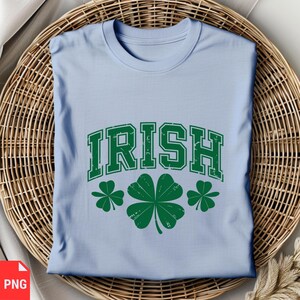 Puede incluir: Camiseta azul claro con la palabra "IRISH" en una fuente universitaria vintage verde. Tres tr&eacute;boles verdes est&aacute;n debajo de la palabra.