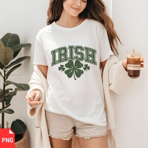 Puede incluir: Camiseta blanca con la palabra "IRISH" en letras verdes en bloque y un gr&aacute;fico de tr&eacute;bol de cuatro hojas verde.