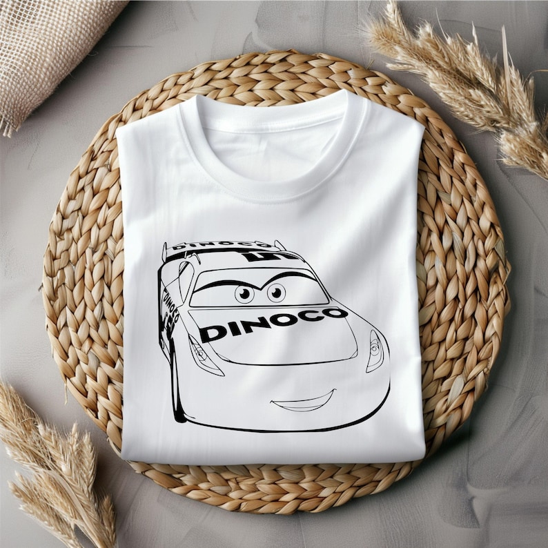 Puede incluir: Camiseta blanca con una ilustraci&oacute;n en blanco y negro de un coche de carreras de dibujos animados con la palabra "Dinoco" en el lateral.