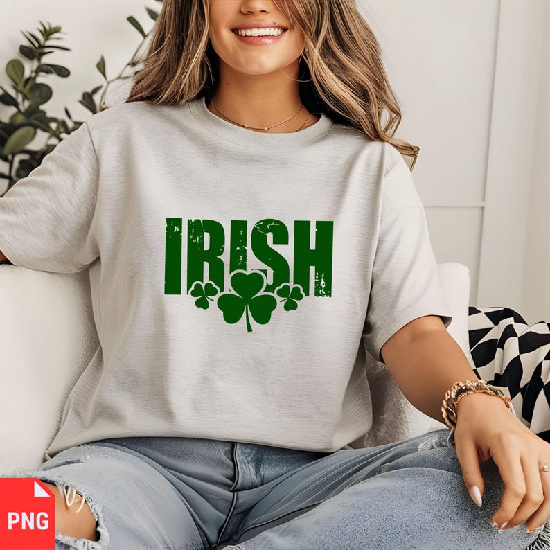 Puede incluir: Una camiseta gris con la palabra "IRISH" impresa en verde con un aspecto desgastado. Tres tr&eacute;boles verdes se encuentran debajo de la palabra.