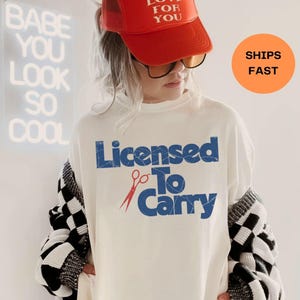"Licensed to Carry" Hairdresser Shirt. 

Looking for the perfect gift for the hair magician in your life? Whether it’s a birthday gift, graduation gift, or just because they slay with scissors, this bold hairstylist shirt is equal parts stylish and hilarious. Designed for comfort and daily wear, it’s a subtle nod to salon life that every hairdresser, hair stylist, or stylist-in-training will appreciate.