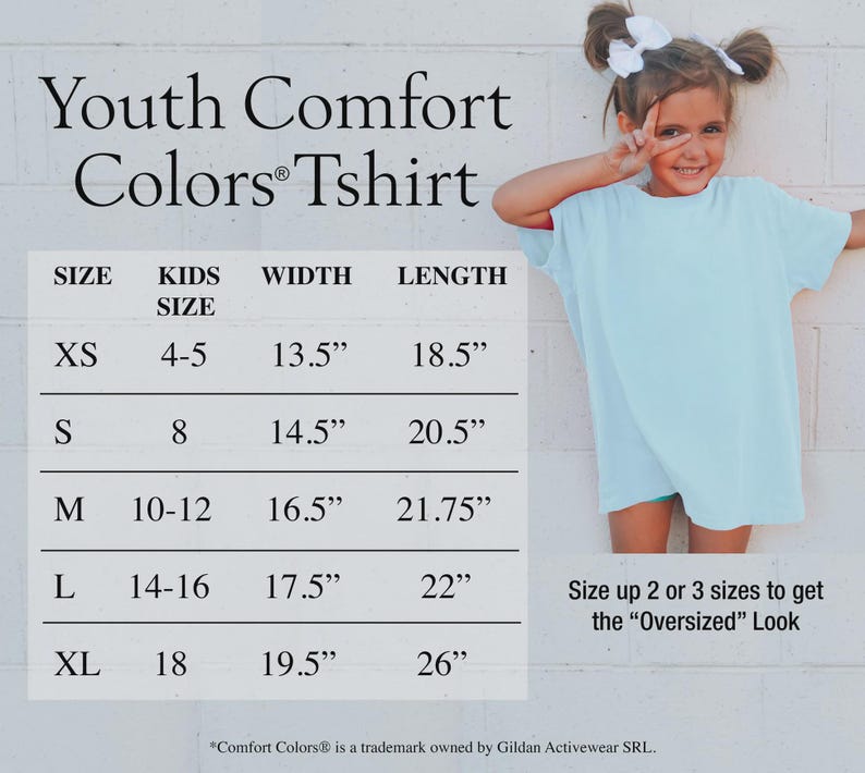 Puede incluir: Una camiseta Comfort Colors juvenil azul claro con una tabla de tallas. La tabla enumera las tallas XS a XL, con medidas de ancho de 34,3 cm a 49,5 cm y largos de 47 cm a 66 cm. Una ni&ntilde;a peque&ntilde;a que lleva la camiseta est&aacute; en la imagen.