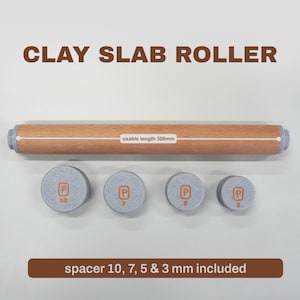 Könnte beinhalten: Eine Tonplattenwalze mit einem Holzkörper, 300 mm Nutzbare Länge, und vier grauen Abstandshaltern unterschiedlicher Dicke. Der Text "CLAY SLAB ROLLER" steht oben, und "spacer 10, 7, 5 & 3 mm included" steht unten.