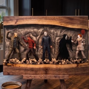 Può includere: Una tavola di legno rettangolare con un inserto centrale in resina contenente cinque statuette di personaggi di film horror in piedi su un letto di piccoli teschi. Le figure includono Jason Voorhees, Freddy Krueger, Michael Myers, Ghostface e Pennywise.