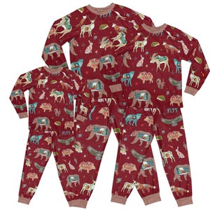 May include: A set of red pyjamas with a woodland animal print featuring bears, deer, and birds. The pyjamas are available in different sizes for adults and children.
