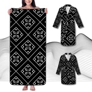 Puede incluir: Bata de baño negra y blanca con un patrón geométrico. La bata tiene un cuello chal y un cinturón de atar.