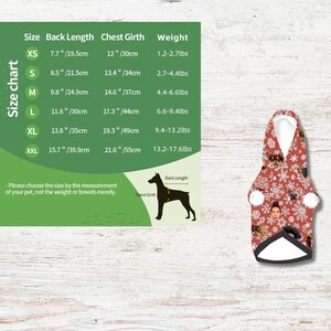 Puede incluir: Una sudadera con capucha roja para perros con interior blanco, adornada con un patr&oacute;n de copos de nieve y caras de perros. Se muestra una tabla de tallas con medidas en cm y kg para largo de espalda, contorno de pecho y peso.