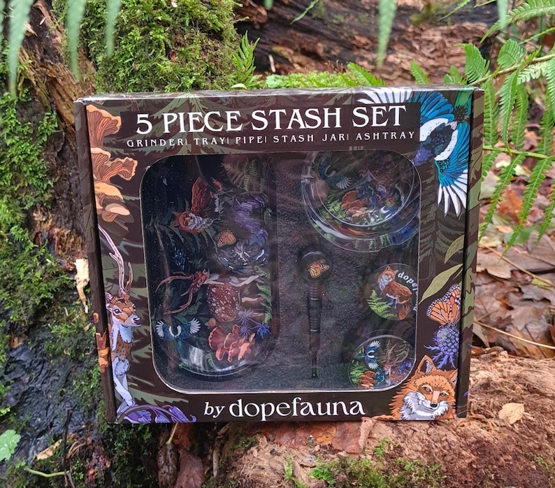 May include: A 5-piece stash set in a decorative box. The box features illustrations of wildlife and the text "5 PIECE STASH SET". The set includes a grinder, tray, pipe, stash jar, and ashtray. The brand name "dopefauna" is also visible.