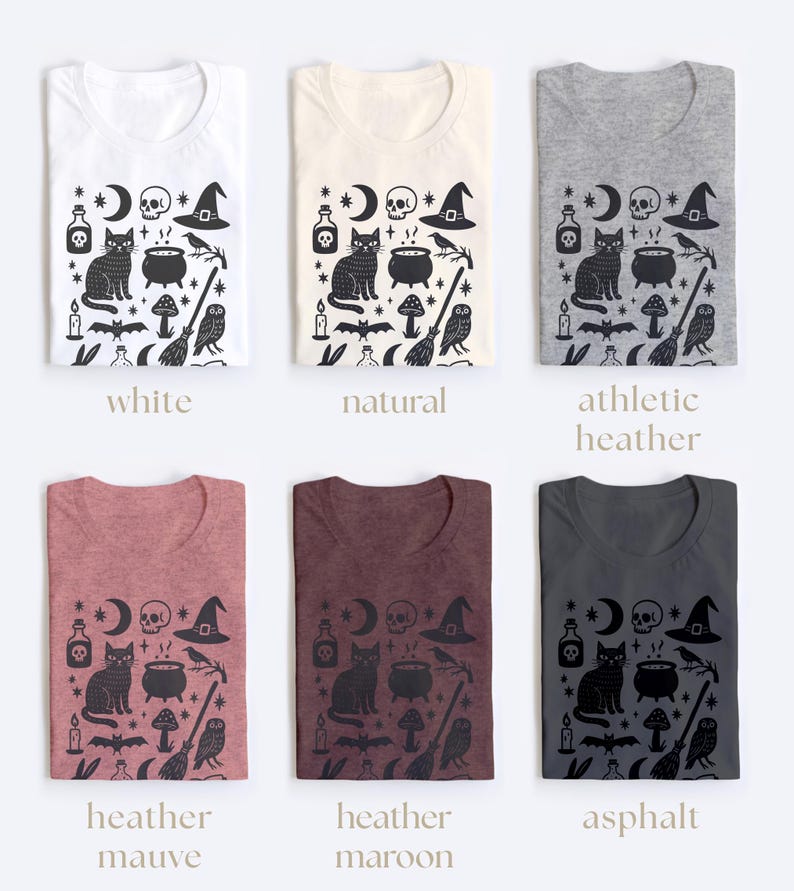 May include: Six t-shirts in various colors, each featuring a black graphic design with witchy elements. The design includes a cat, cauldron, moon, skull, witch hat, and other mystical symbols. Colors include white, natural, athletic heather, heather mauve, heather maroon, and asphalt.