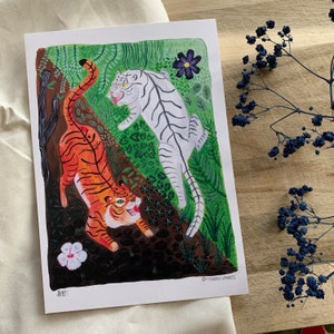 Op de afbeelding: Een kleurrijke illustratie van twee tijgers in een jungle-omgeving. De ene tijger is oranje en zwart, de andere is wit met zwarte strepen. De tijgers kijken elkaar aan, waarbij de oranje tijger naar de witte tijger kijkt. De achtergrond is een weelderige groene jungle met bloemen en bladeren.