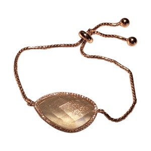 Peut inclure: Un bracelet ajustable en or rose avec un pendentif en pierre précieuse facetté transparent.