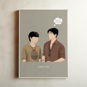 May include: A framed art print with a minimalist illustration of two figures on a grey background. One figure wears a brown shirt, the other a tan shirt. The print includes text in a thought bubble and the name "KHEMJIRA".