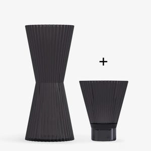 May include: Two black glass vases with a pleated design. The larger vase is taller and wider than the smaller vase.
