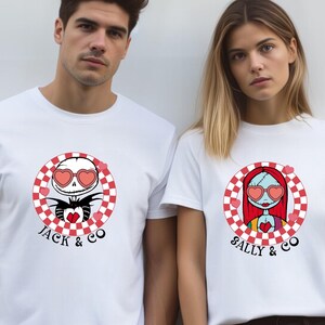 May include: Two white t-shirts with a chequered circle design featuring Jack and Sally from The Nightmare Before Christmas. Jack is wearing heart-shaped sunglasses and holding a red heart. Sally is wearing heart-shaped sunglasses and has red hair. The text "Jack & Co" is below Jack's image and "Sally & Co" is below Sally's image.