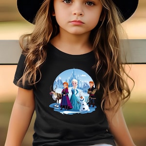 May include: A black t-shirt with a colorful graphic of the characters from the movie Frozen. The graphic features Elsa, Anna, Kristoff, Olaf, and Sven in front of the ice castle.