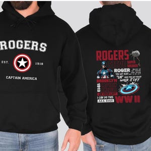 Puede incluir: Sudadera con capucha negra con tem&aacute;tica de Capit&aacute;n Am&eacute;rica. La parte delantera presenta las palabras "Rogers" con el escudo del Capit&aacute;n Am&eacute;rica y el texto "Est. 1918 Capit&aacute;n Am&eacute;rica". La parte trasera presenta las palabras "Rogers Steve Super Soldier" con una imagen del Capit&aacute;n Am&eacute;rica y el texto "I can do this all day WWII".