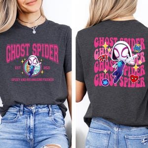 a woman wearing a gray t-shirt with a graphic design of a character resembling Spider-Man.