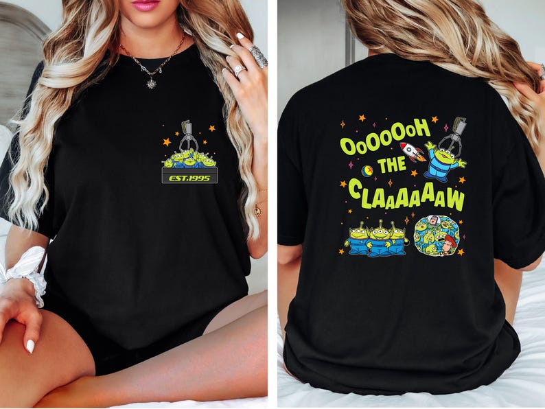 May include: Black t-shirt featuring a graphic of the claw machine with green aliens and the text "EST.1995" on the front. The back of the shirt has the text "Ooooooh the Claaaaaw" with alien characters and a rocket ship.