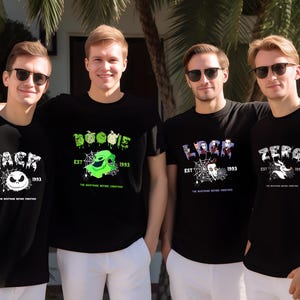 Puede incluir: Cuatro personas con camisetas negras con dise&ntilde;os de "Pesadilla antes de Navidad". Cada camiseta presenta un personaje diferente: Jack, Oogie Boogie, Lock y Zero, con el texto "EST 1993."