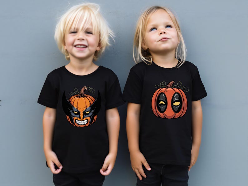 Two young children wearing black t-shirts with Halloween-themed designs, including a pumpkin and a mask.