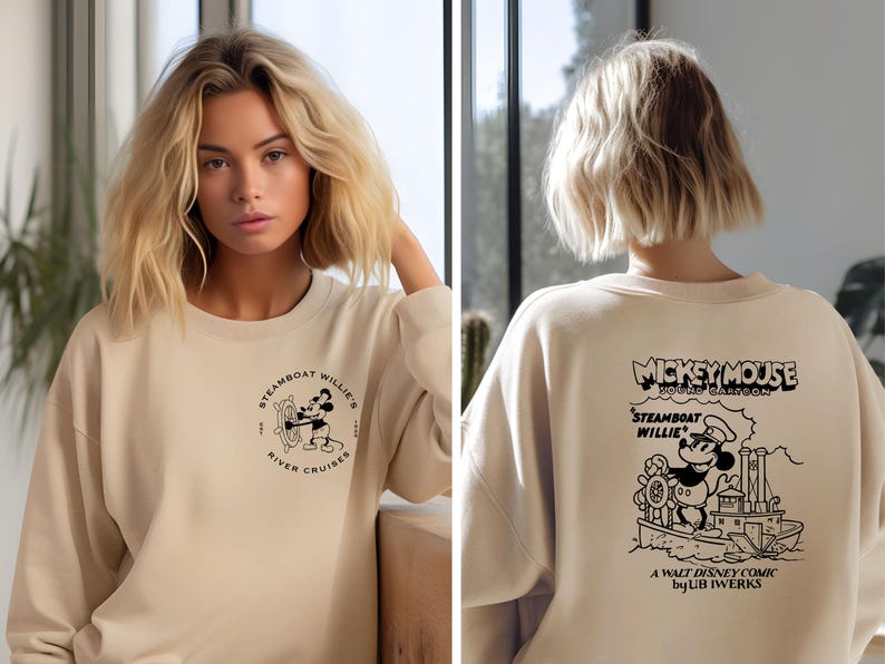 May include: A beige sweatshirt with a black and white graphic of Mickey Mouse on a steamboat. The text "Mickey Mouse" and "Steamboat Willie" is printed on the sweatshirt. The text "A Walt Disney Comic by UB Iwerks" is also printed on the sweatshirt.