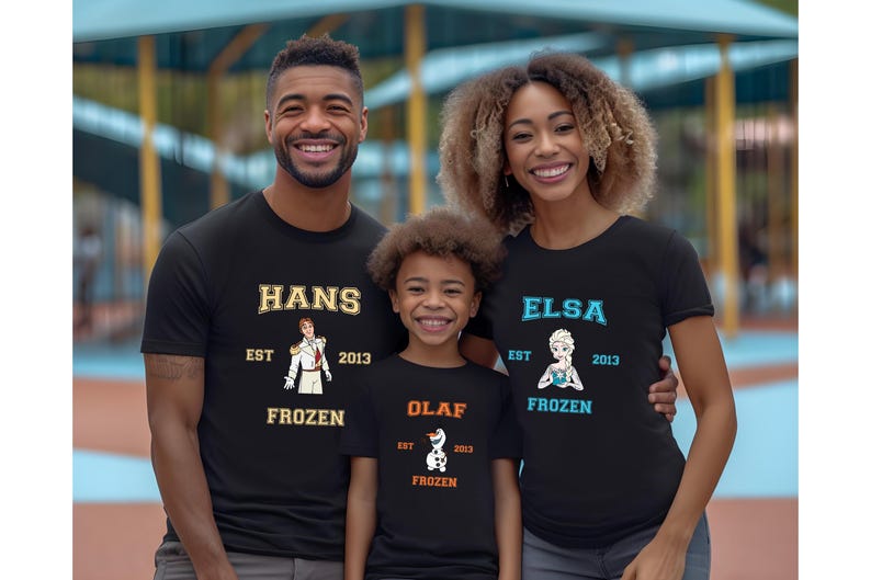 May include: A family of three wearing black t-shirts with Frozen character graphics. The shirts have the text "Hans Est 2013 Frozen", "Elsa Est 2013 Frozen", and "Olaf Est 2013 Frozen".