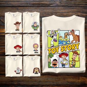 A collection of white t-shirts featuring cartoon characters from the Toy Story franchise, along with a white t-shirt displaying the characters from the Toy Story movie.