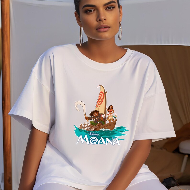 May include: White t-shirt with a graphic of Moana and Maui sailing on a boat with the text "Disney Moana" on the front.