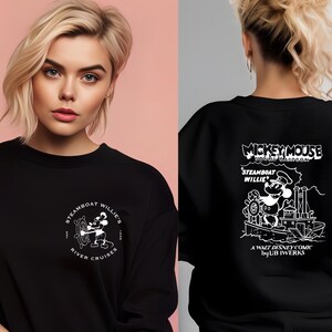 May include: Black sweatshirt with a white graphic of Mickey Mouse on a steamboat. The graphic includes the text "Mickey Mouse", "Steamboat Willie", "A Walt Disney Comic by UBB IWERKS", and "River Cruises".